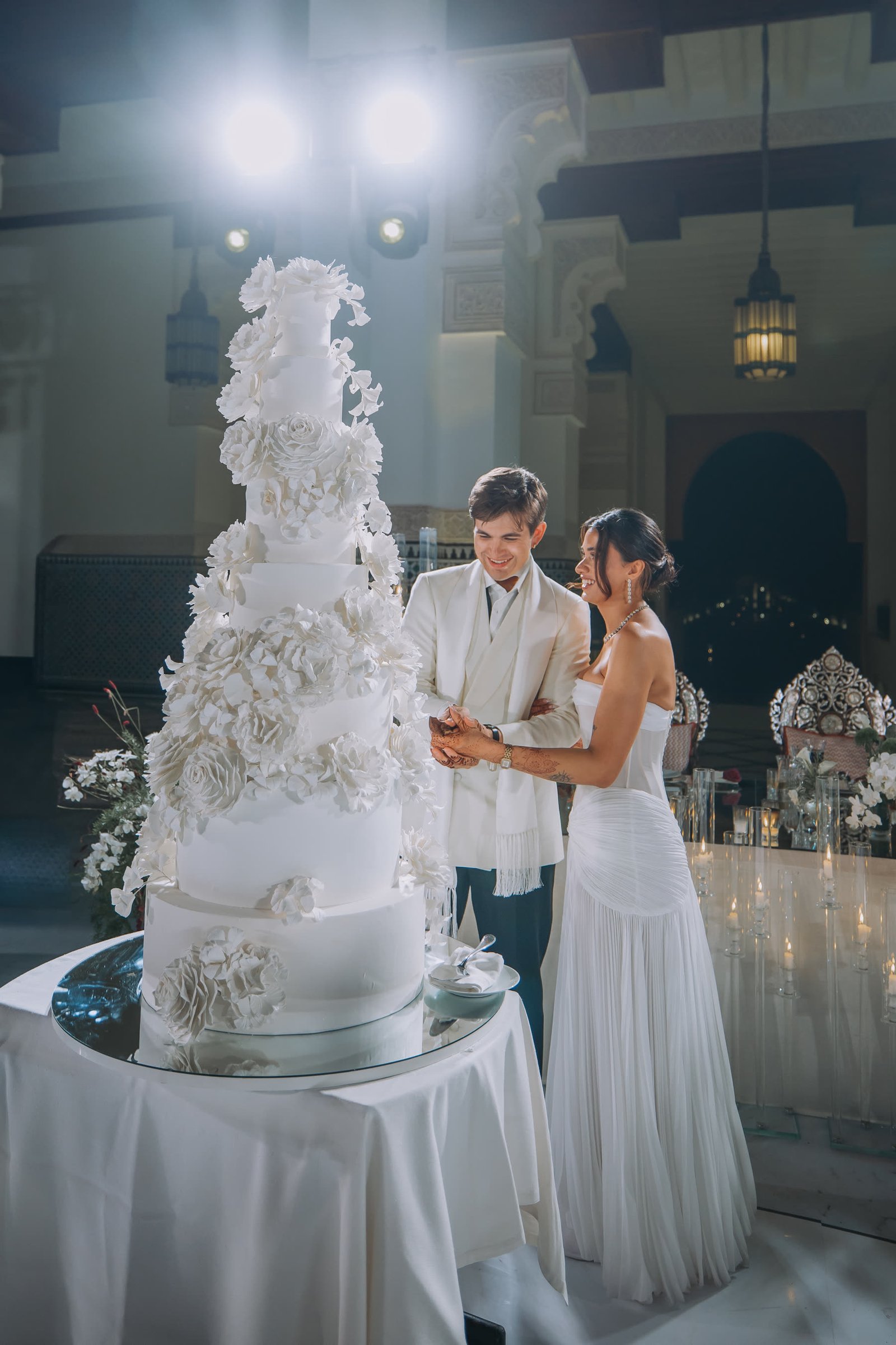 Henna and Ben cutting their wedding cake at night