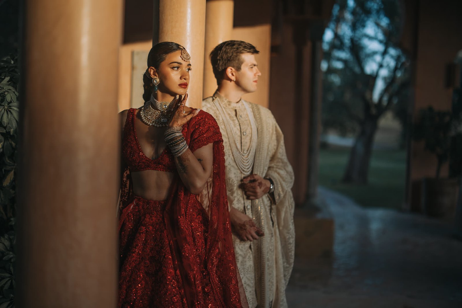 Henna in a red lehenga and Ben in a sherwani at night, Marrakech