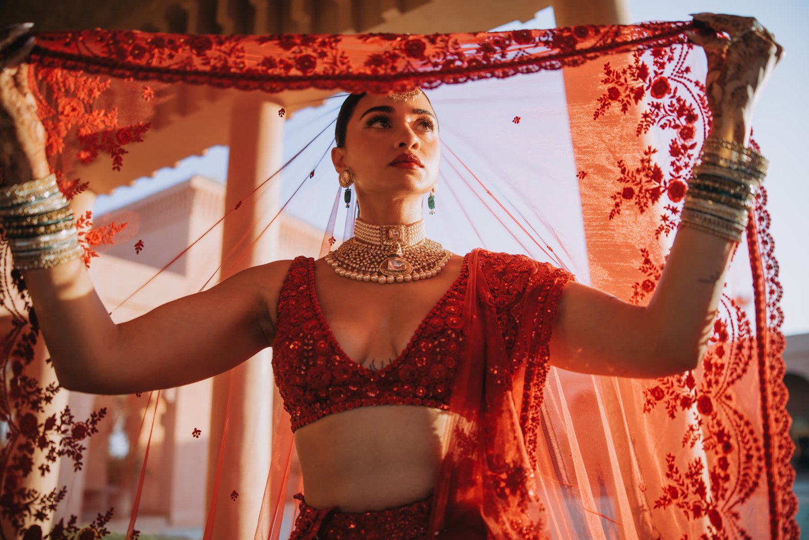 Henna lifting her red embroidered veil in the Marrakech sun