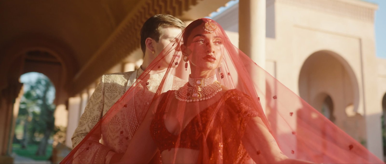 Henna beneath her red veil in Marrakech, a still from Henna and Ben's wedding film by Chromata Films