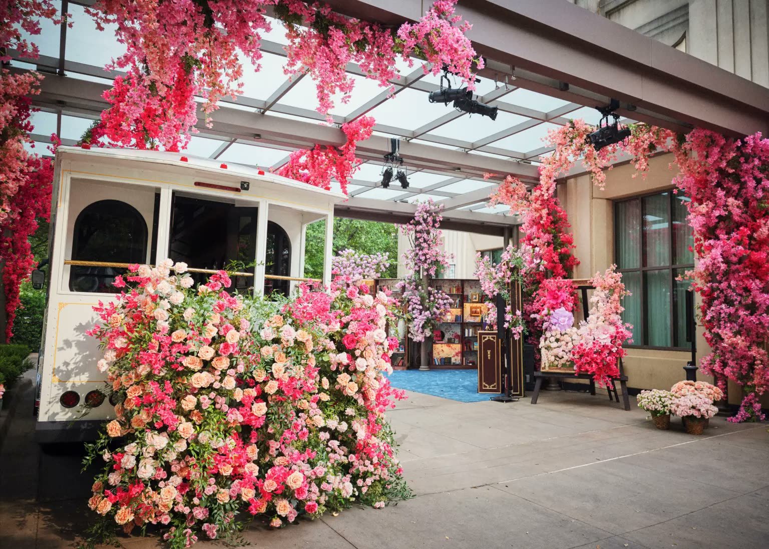 A vintage trolley car under a cascading rose and floral canopy entrance at Marcella Raneri and Daniel Nutkis's engagement party, Ritz-Carlton Dallas