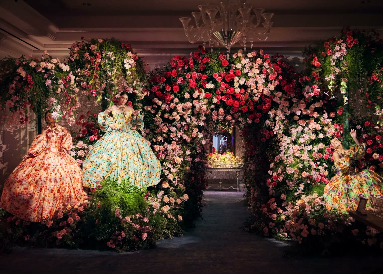 Models in couture floral gowns beneath a rose archway at Marcella Raneri and Daniel Nutkis's floral-themed engagement party