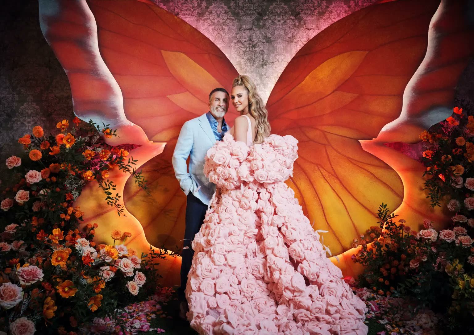 Marcella Raneri and Daniel Nutkis pose in front of a floral butterfly-wing backdrop at their Ritz-Carlton Dallas engagement party