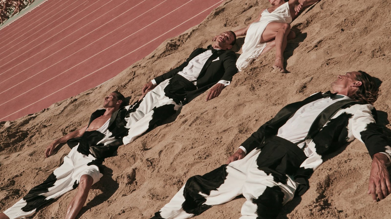 Aerial view of grooms in black tuxedos lined up on an athletics track like sprinters at the start — AI wedding editorial