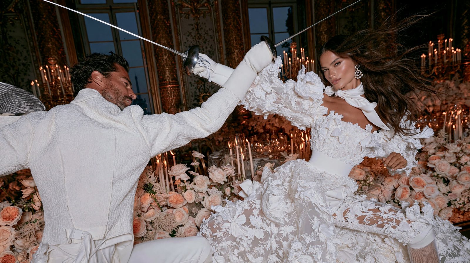 A couple fencing in a candlelit ballroom, the bride in an ornate white gown